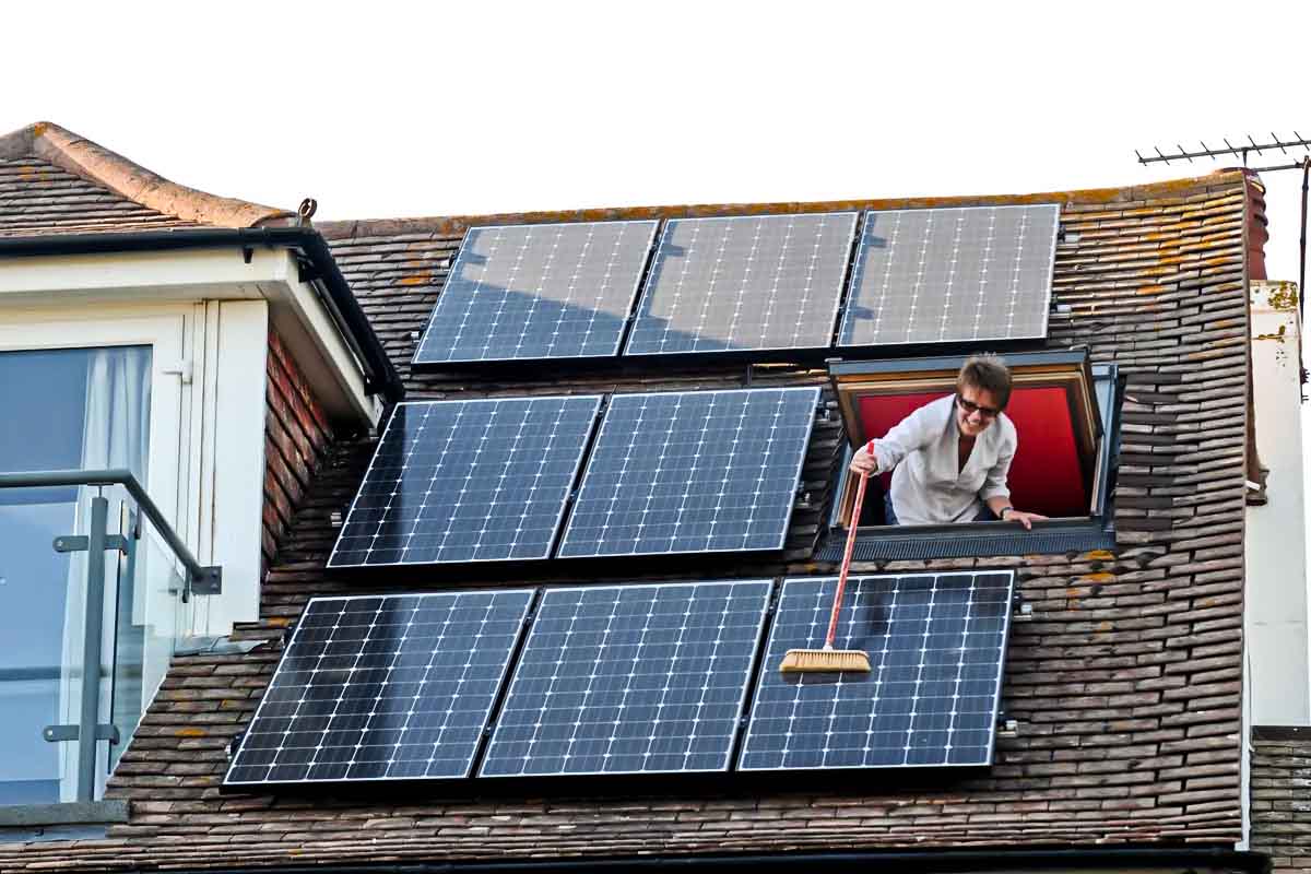 senora limpiando paneles solares casa